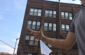 Machen ein Super PaperJet und fliegen über einem 5-stöckigen Gebäude
